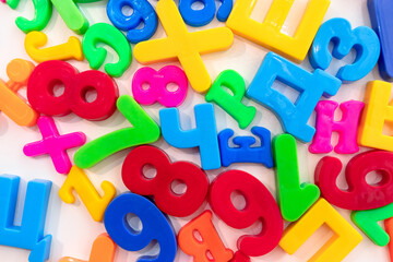 Multi-colored plastic letters on a white background. Fridge magnets in the form of letters