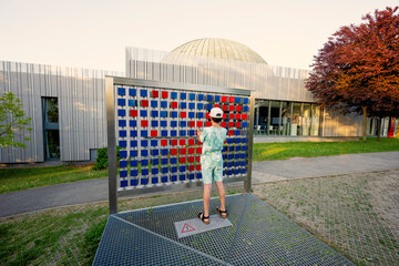 Boy making heart from steel cubes mosaics at observatory park in planetarium.