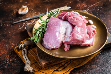 Fresh skinless raw Turkey thigh fillet meat with spices. Dark background. Top view