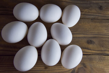 A dozen white chicken eggs on a wooden table. Place for text. The concept of farm products, an environmentally friendly product. Advertising products rustic still life. Advertising communication MTS