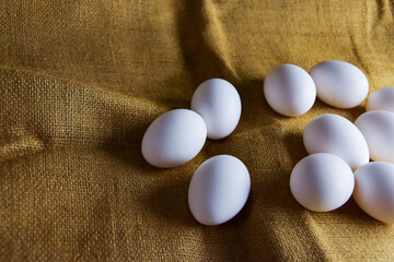 White chicken eggs close-up on a background of burlap, rustic still life. Concept and idea for homemade organic food artwork. environmentally friendly products. Farm products