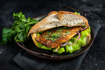 Sandwich balik Ekmek with grilled fillet of mackerel fish, tomatoes, onions and lettuce. Black...