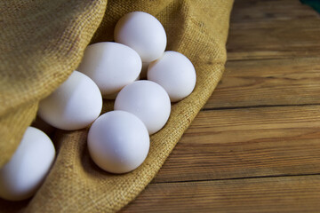 White chicken eggs close-up on a background of burlap, rustic still life. Concept and idea for homemade organic food artwork. environmentally friendly products. Farm products