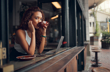 Young woman, content and drink coffee at cafe for relax, peaceful and focused on work with laptop. Female, girl and hot beverage or tea in hand take a break, for lunch and thinking in coffee shop.