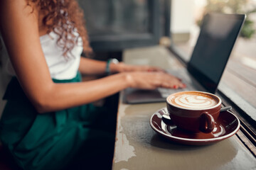 Fototapeta na wymiar Laptop, coffee and woman remote work typing proposal, for planning business and in cafe. Entrepreneur, female student and lady working on startup company, strategy and with hot beverage or latte.