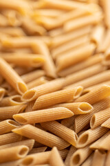 Uncooked whole grain pasta. Raw penne pasta.