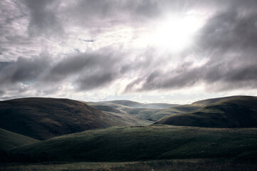 Early morning sun breaking through the cloud over Coquetdale, the Cheviot Hills in Northumberland,...