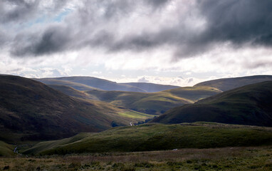 Early morning sun trying to break through the cloud over Coquetdale, the Cheviot Hills in Northumberland, England, UK.