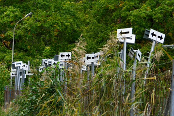 Stored arrow signs behind a fence