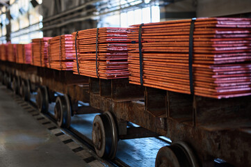 Cathode copper sheets on rail carriages in warehouse
