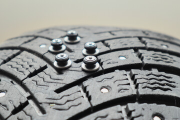Worn tire tread, winter studded tire - wheel repair service. Renew Lost studs. Old winter studded tire close up. Used snow tire with missing steal studs closeup.