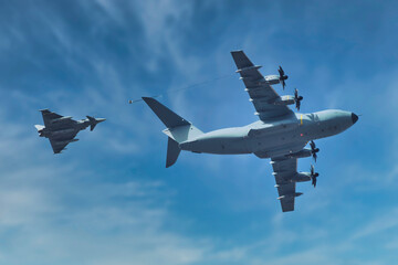 A400M AAR refueling eurofighter military aircrafts on sightly cloudy sky