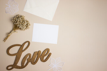 White notes with white flowers with Love letter on brown background. 