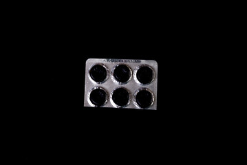 Сapsule pills in blister on a black background