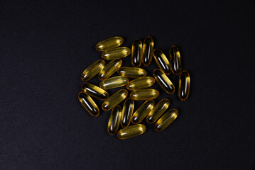 Medical orange pills on isolated on black background