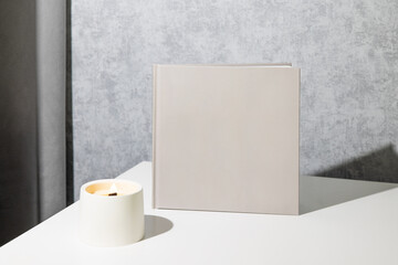 Grey book mock up, great design for any purposes. Technology concept with candle. Business concept in grey room interior 