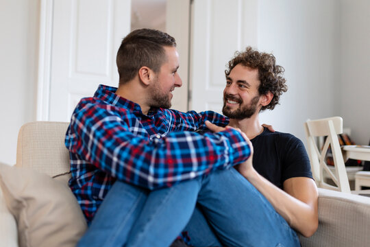 Loving Same Sex Male Gay Couple Lying On Sofa At Home And Relaxing, cuddling Together