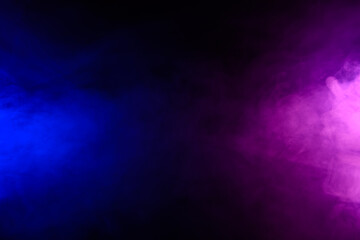 Smoke clouds in blue and purple neon light swirling on black table background with reflection