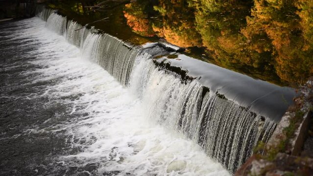 Wehr an einem Fluss im Herbst