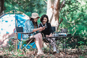 Obraz na płótnie Canvas Asian pretty woman and girlfriend use smartphone selfie on camping.