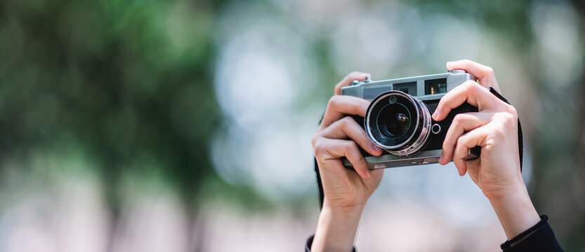 Hands of Female Professional photographer takes snapshots in forest