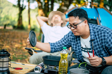 Asian relaxed man sitting and waiting for his friend cooking