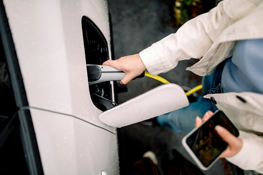 Directly above shot of woman charging electric car