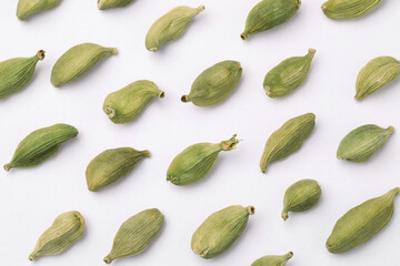 Many dry cardamom pods on white background, flat lay