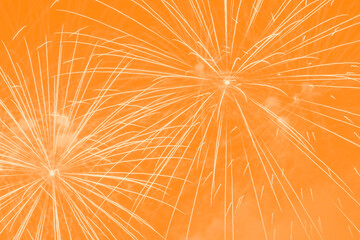 holiday background with yellow fireworks against orange