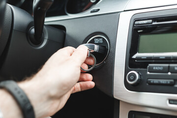 Man Hand Insert Key into the Lock of Ignition of car. Car ignition key