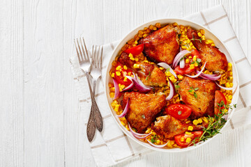 roast chicken with corn and tomatoes on plate