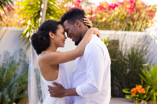 Happy african american couple getting married, embracing during wedding day
