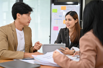 Professional Asian businesswoman discussing with her colleague in the financial meeting.
