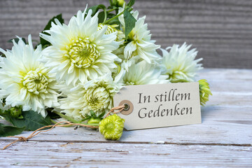 Mourning card with white dahlias and German text: In silent memory