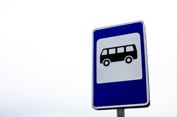 Blue and white bus stop sign in Europe against the sky