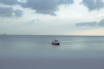 a beautiful sea and a fast white boat on it.