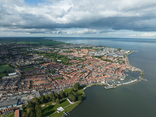 Volendam, Netherlands. Traditional dutch fishing village city traditional buildings and harbor. Touristic attraction sky clouds and urban city skyline. Aerial drone view.