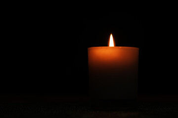 white candle light in the dark, grieving concept
