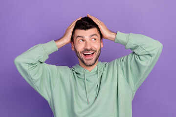 Photo of young excited cute positive student man stubble touch his head surprised good news look empty space isolated on purple color background