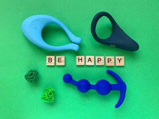 Vibrator, cock ring and anal toy on green background. lettering LOVE TOY. Sex toys, adult toys