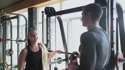 Two Attractive Athletic friends man and woman talks at gym after training