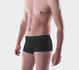 Fototapeta na wymiar Template black cotton masculine boxers on a man, close-up, brief trunks isolated on the background in the studio.