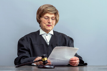 Judge reading the verdict. Judge's gavel on the table in the courtroom. Law Lord wearing gown using a hammer for attention, justice judgment at courts of law