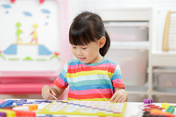 young girl play number blocks for homeschooling