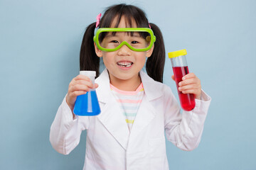 young  girl pretend play scientist role at home against plain background