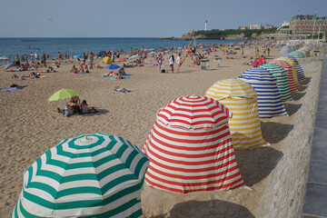 Biarritz, France - 22 July, 2022: Colorful sun shelters on the Grand Plage beach in Biarritz - obrazy, fototapety, plakaty