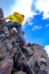 Alpinista supera le corde fisse verso la vetta del Pizzo Scopì, Alpi Lepontine, gruppo dell'Adula,...