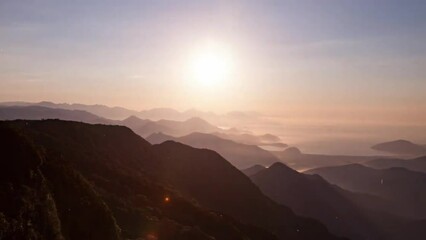 Timelapse of a soft bright sunrise over the mountains