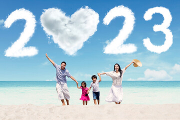 Family with 2023 number and heart symbol on beach