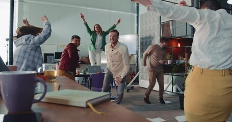 Camera moves around crazy office party, happy business people celebrating raise and success at workplace slow motion.